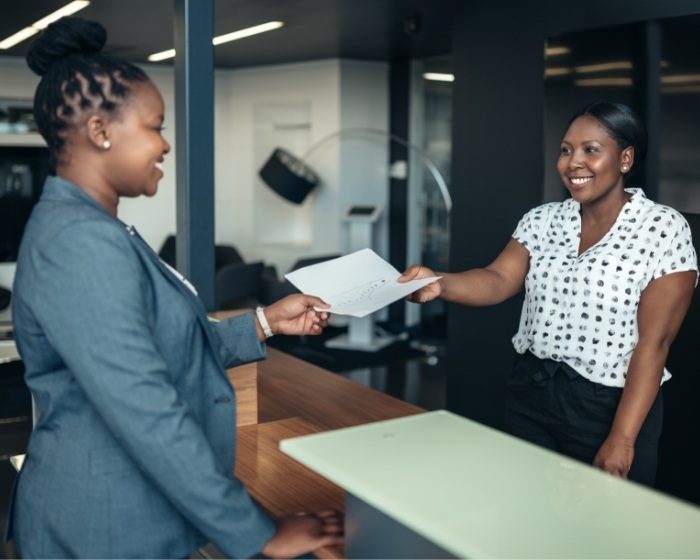 Dental team member handing a paper to a patient