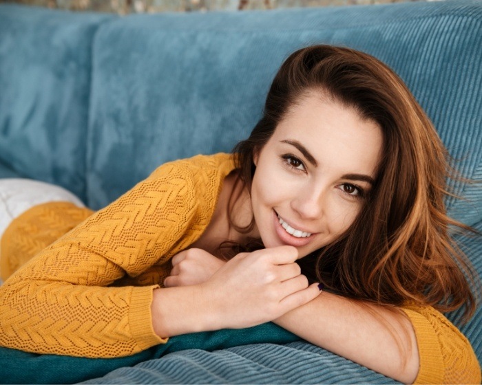 Young woman in yellow sweater smiling