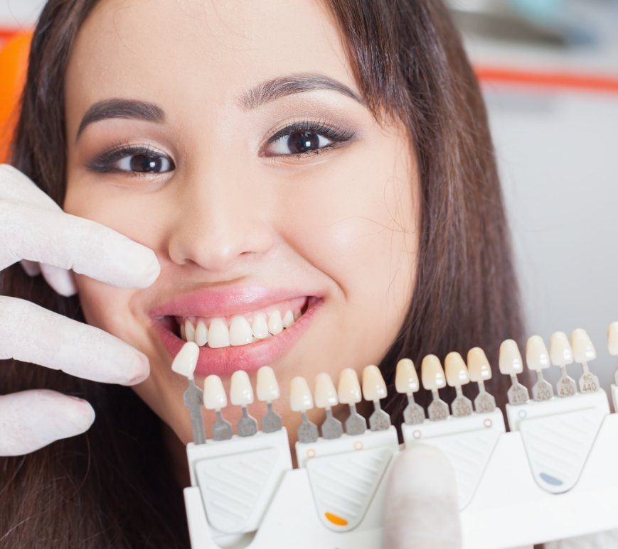 Woman smiling while dentist fits her for veneers