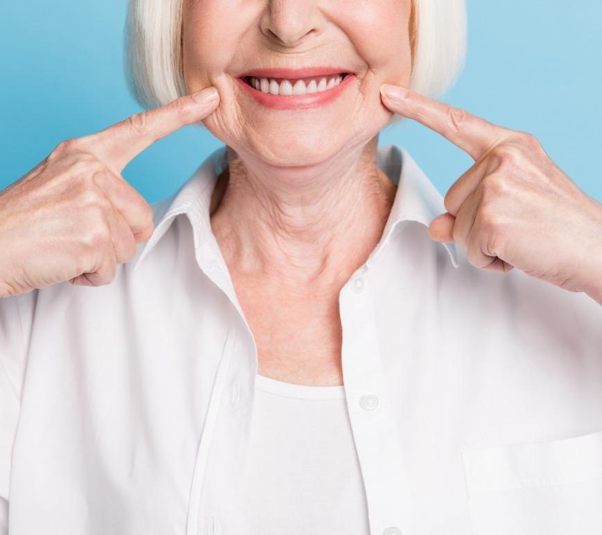 Senior woman pointing to her smile