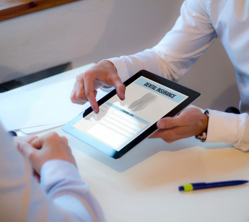 Two people looking at dental insurance information on a tablet