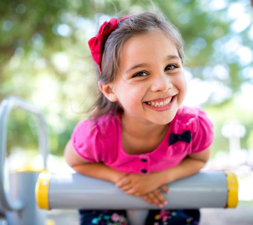 Young girl grinning at outdoor playground