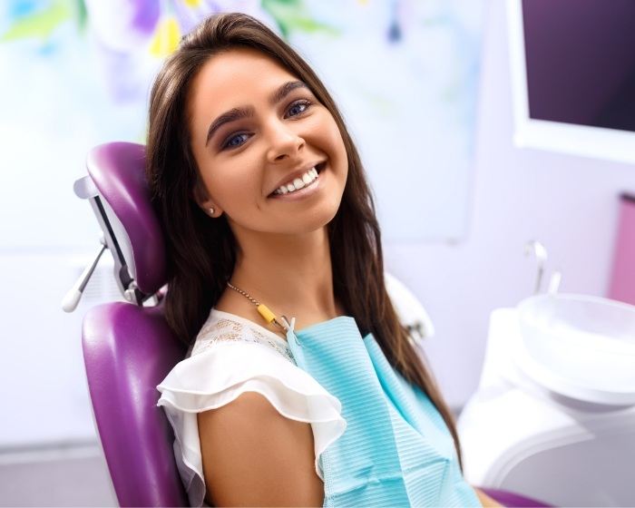 Smiling woman leaning back in dental chair