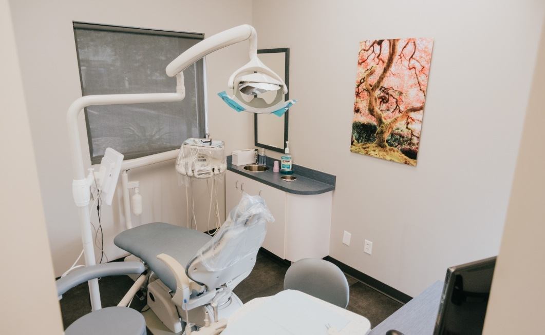 Dental treatment room with painting of tree on wall