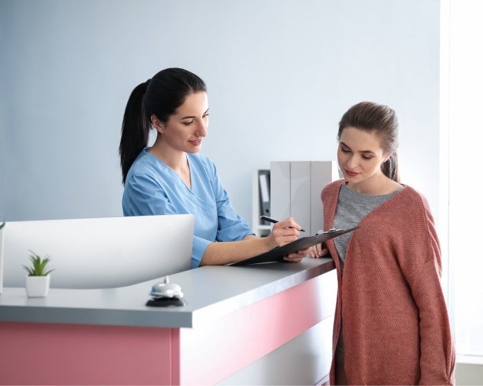 Dental team member showing a clipboard to a patient