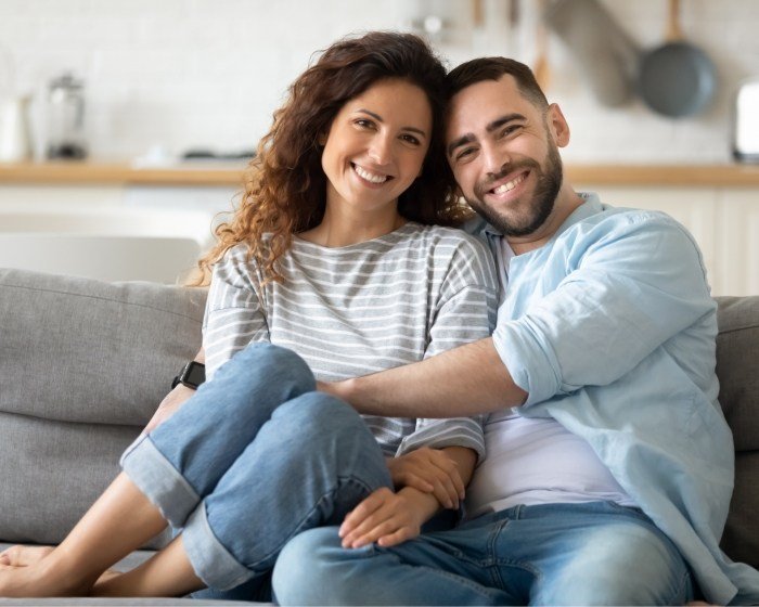 Man and woman snuggling on couch